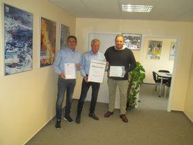 Gebietsleiter Thomas Brübach (rechts) und Niederlassungsleiter Detlef Schöpke (links) überreichten dem Jubilar Peter Wrubel (Mitte) die Urkunden